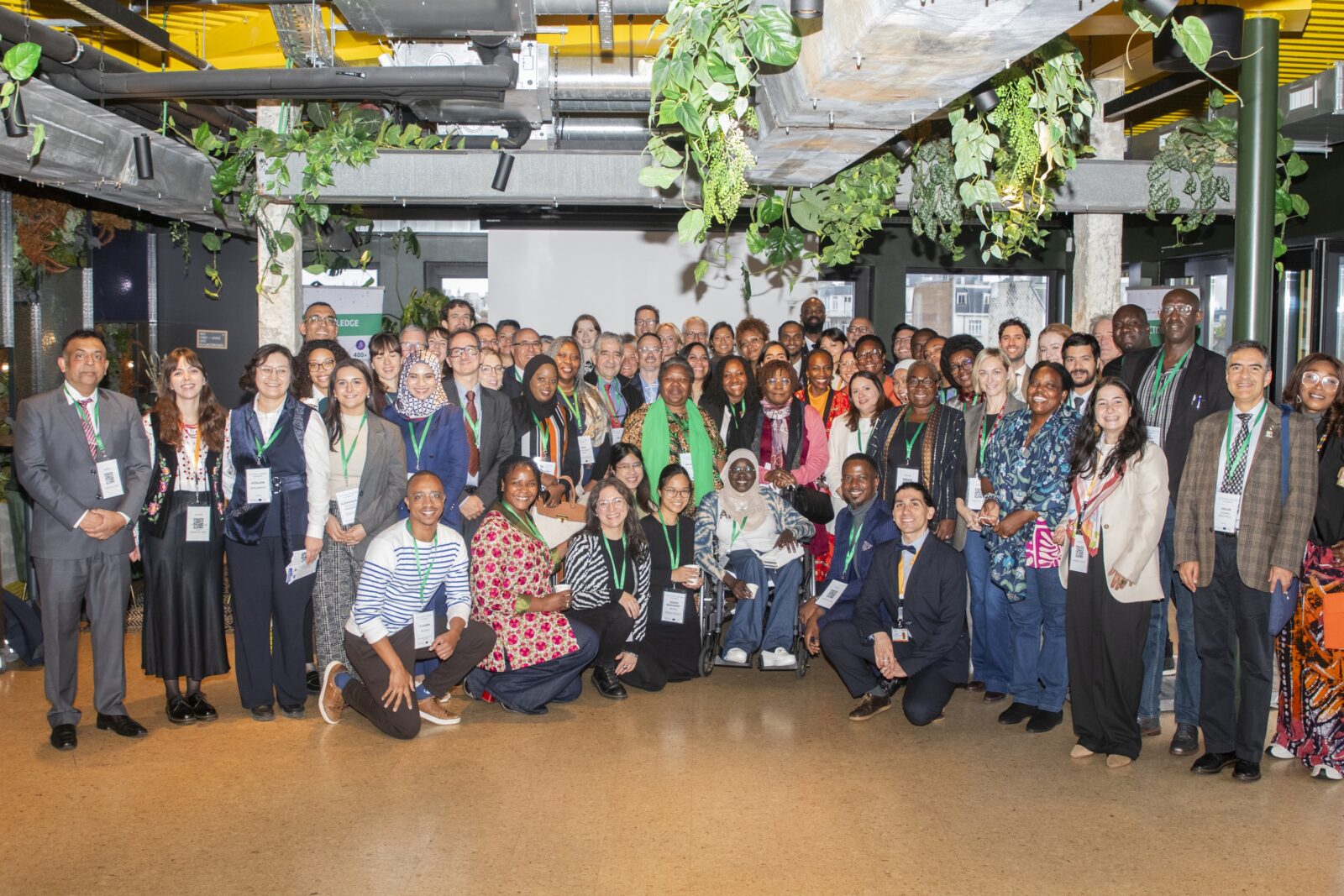 A group of around 80 people posing together at a conference room.