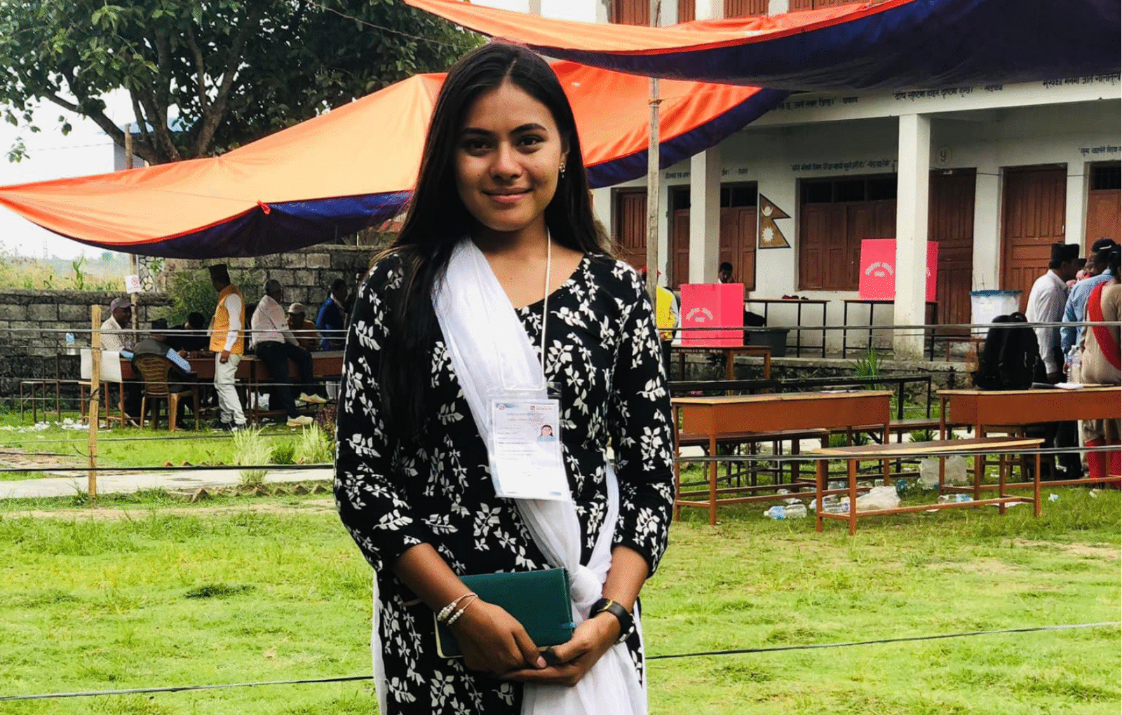 The author, a youth election observer, standing in front of ballot boxes during Nepal’s 2022 elections.