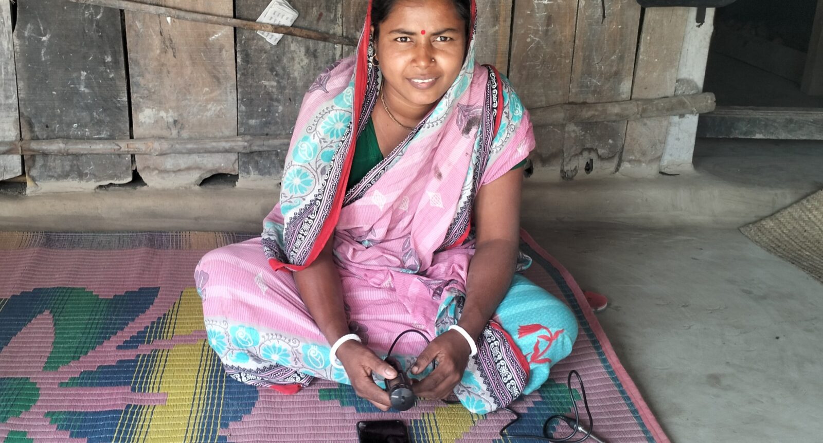 A woman in Bangladesh holding an electronic device.