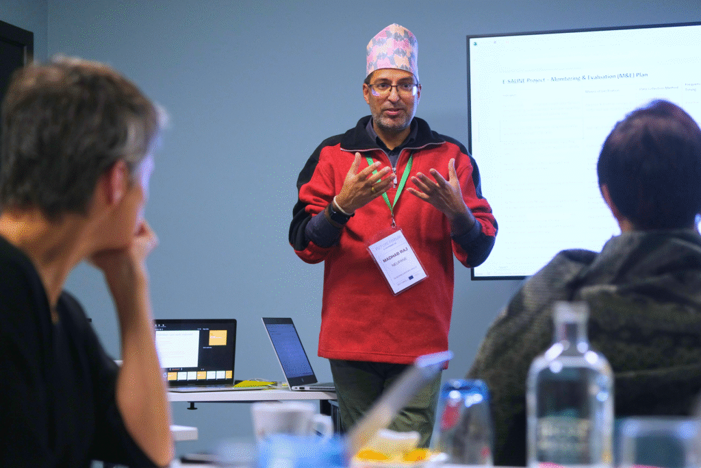 One person stands in front of two people explaining something.