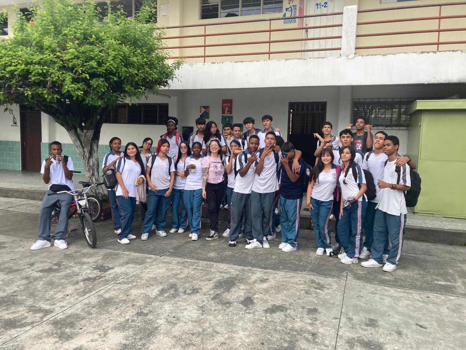 A group of kids in school uniform pose together with Maria Fernanda.